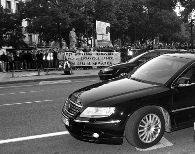 Uno de los vehículos oficiales. Al fondo, una protesta policial