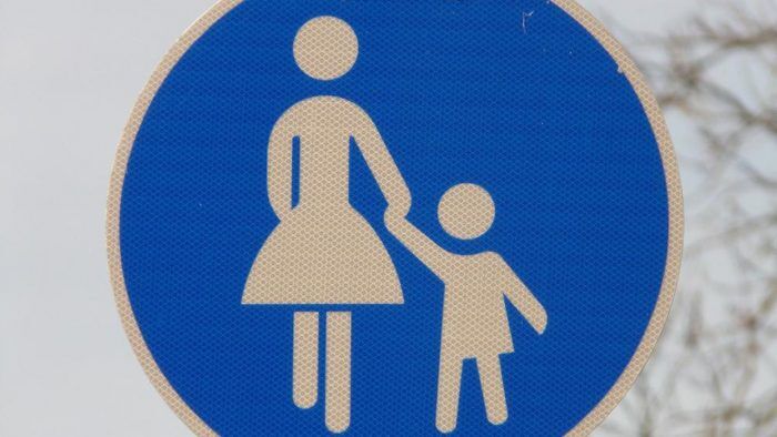 Una Senal Con La Imagen De Un Nino De La Mano De Una Mujer 700x394