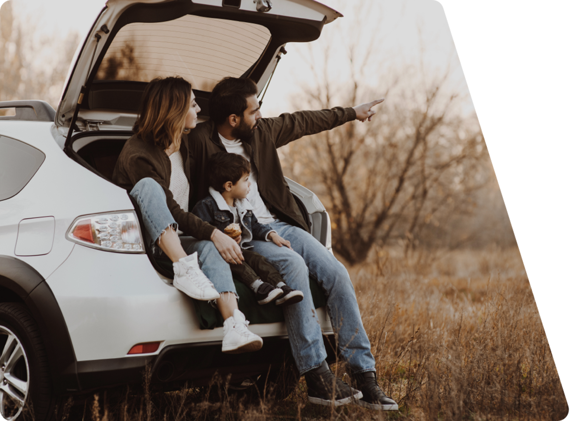 Una familia sentada en su coche nuevo, disfrutando de un momento juntos al aire libre.